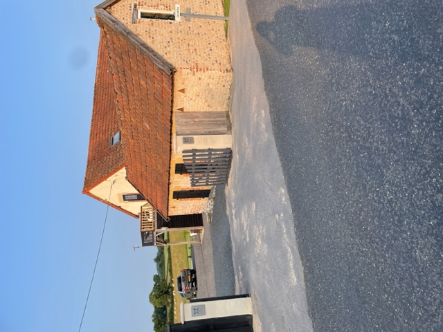 De boerderij en oprit in de avondzon