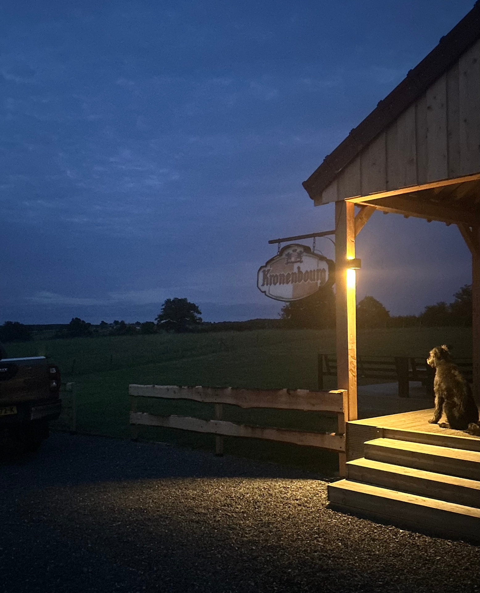 De veranda bij avondlicht, met de hond op de uitkijk